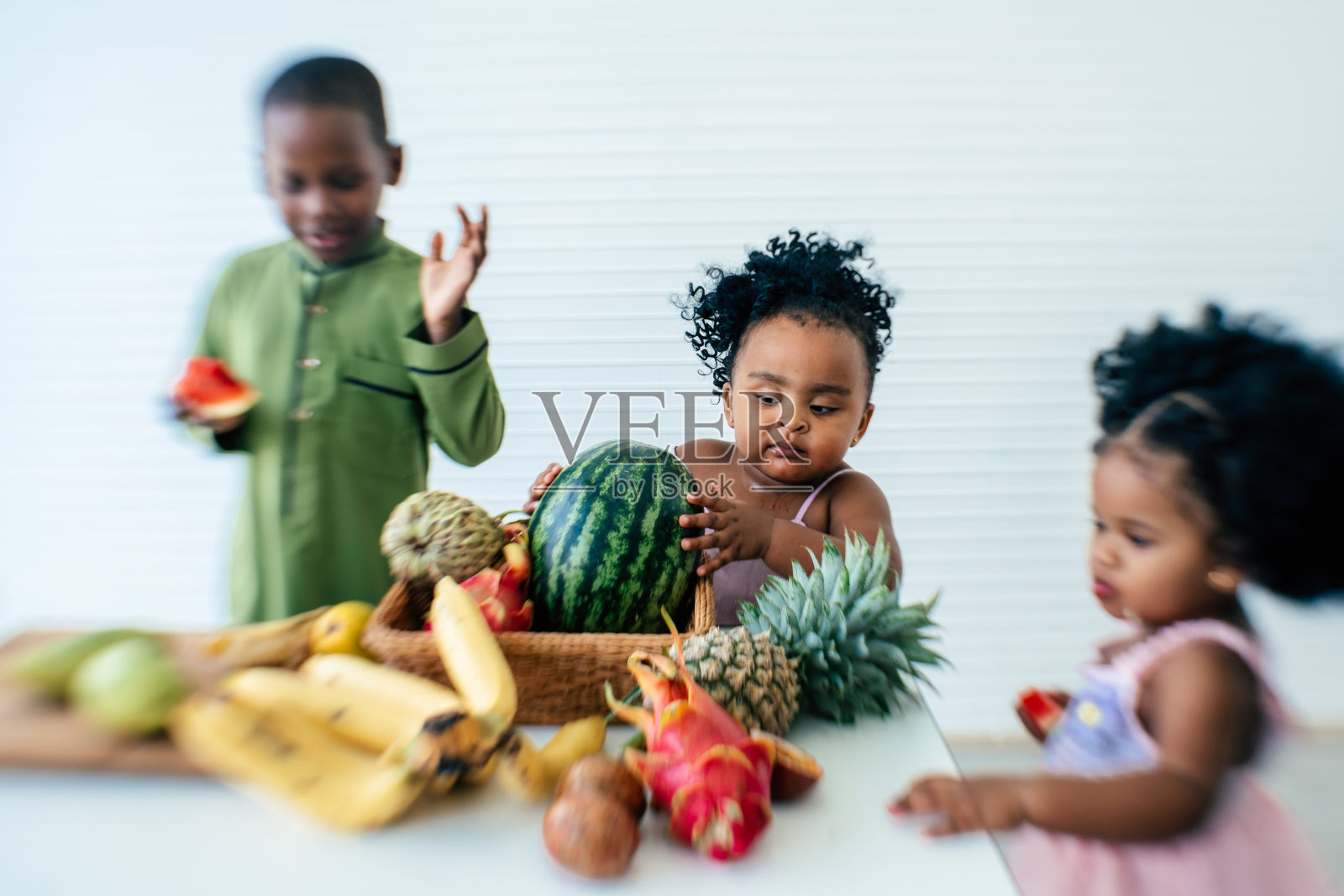 一群吃着各种热带水果的孩子照片摄影图片