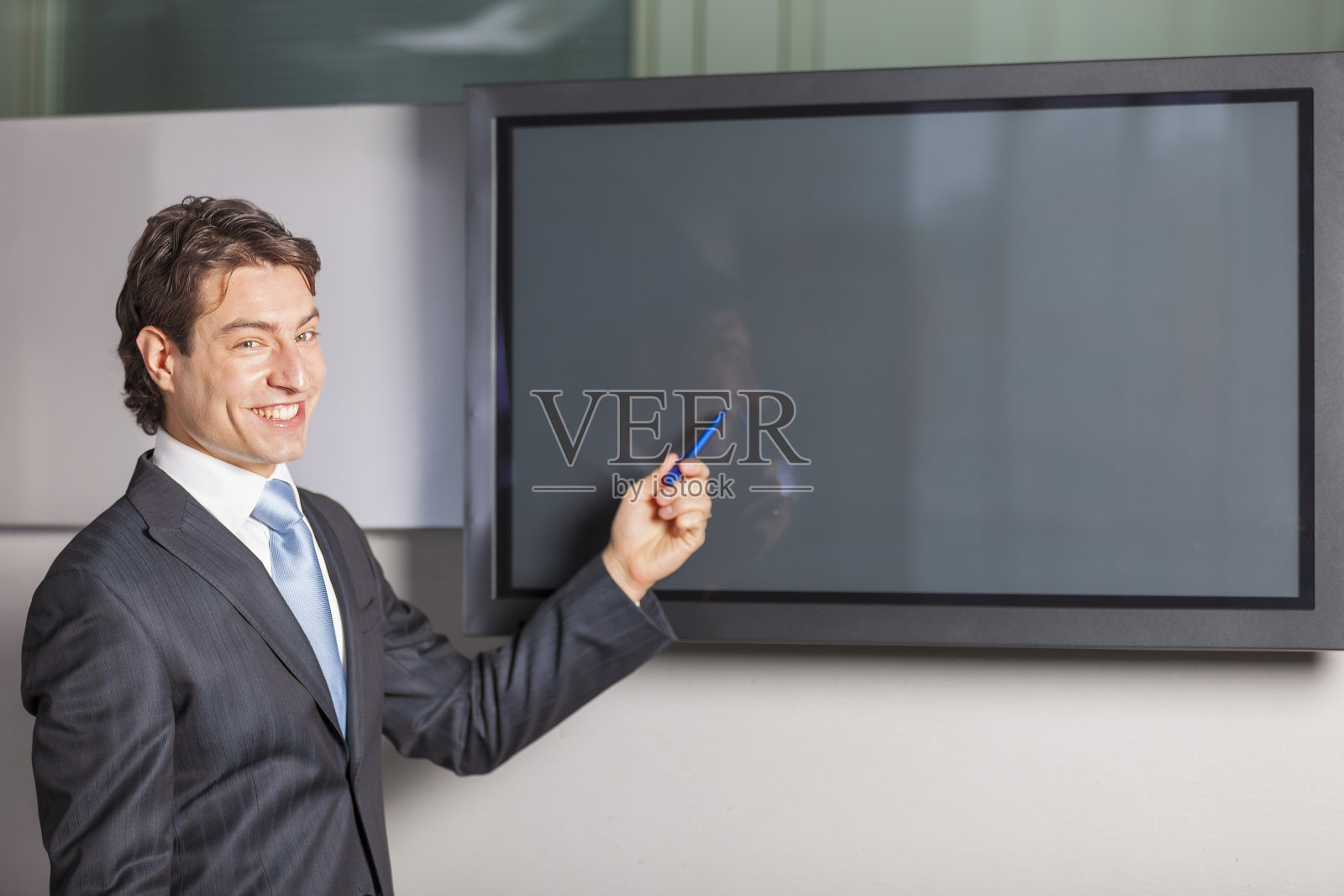商人在空白等离子电视屏幕前的肖像照片摄影图片