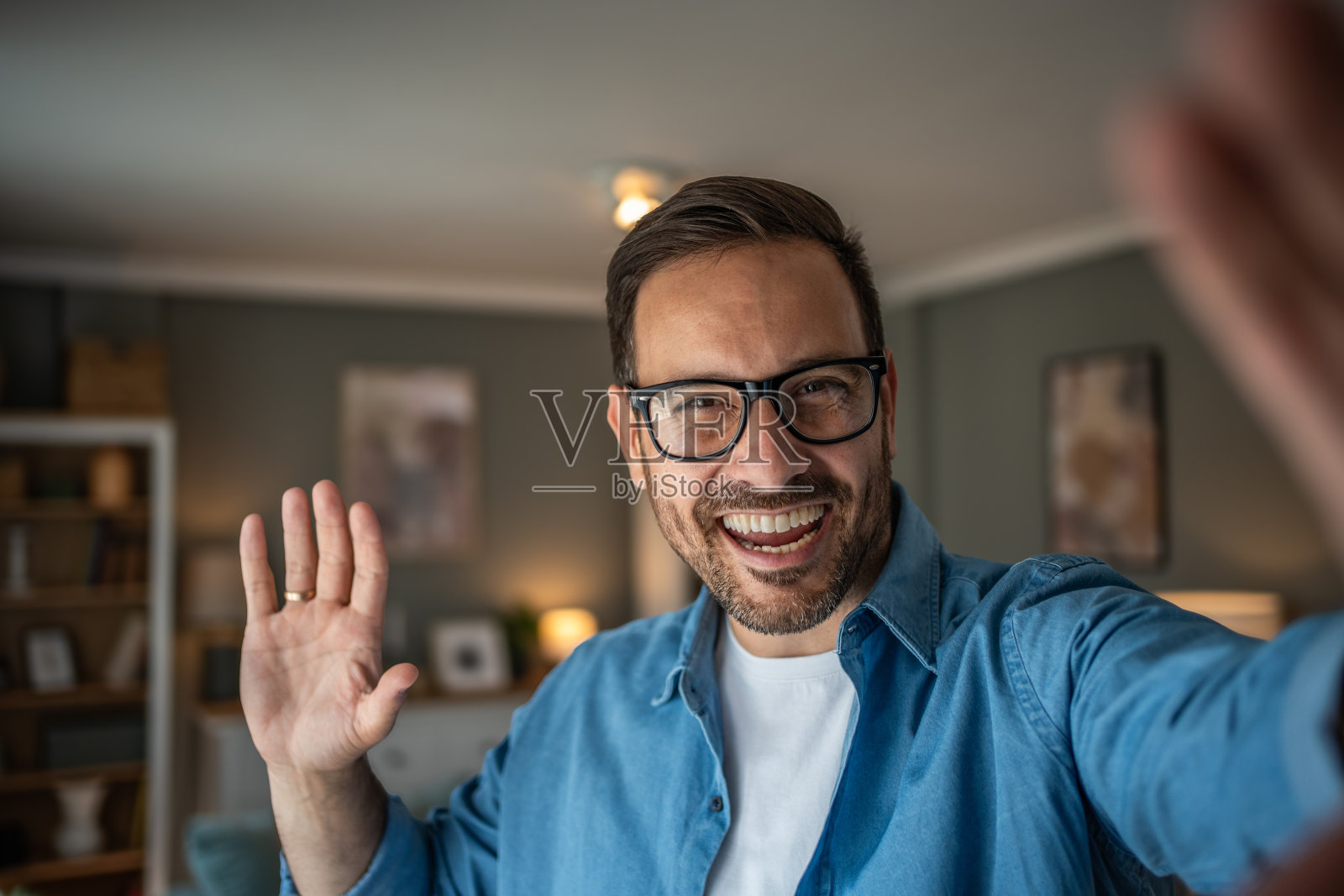 帅气的白人男子在家里的客厅自拍或视频通话照片摄影图片