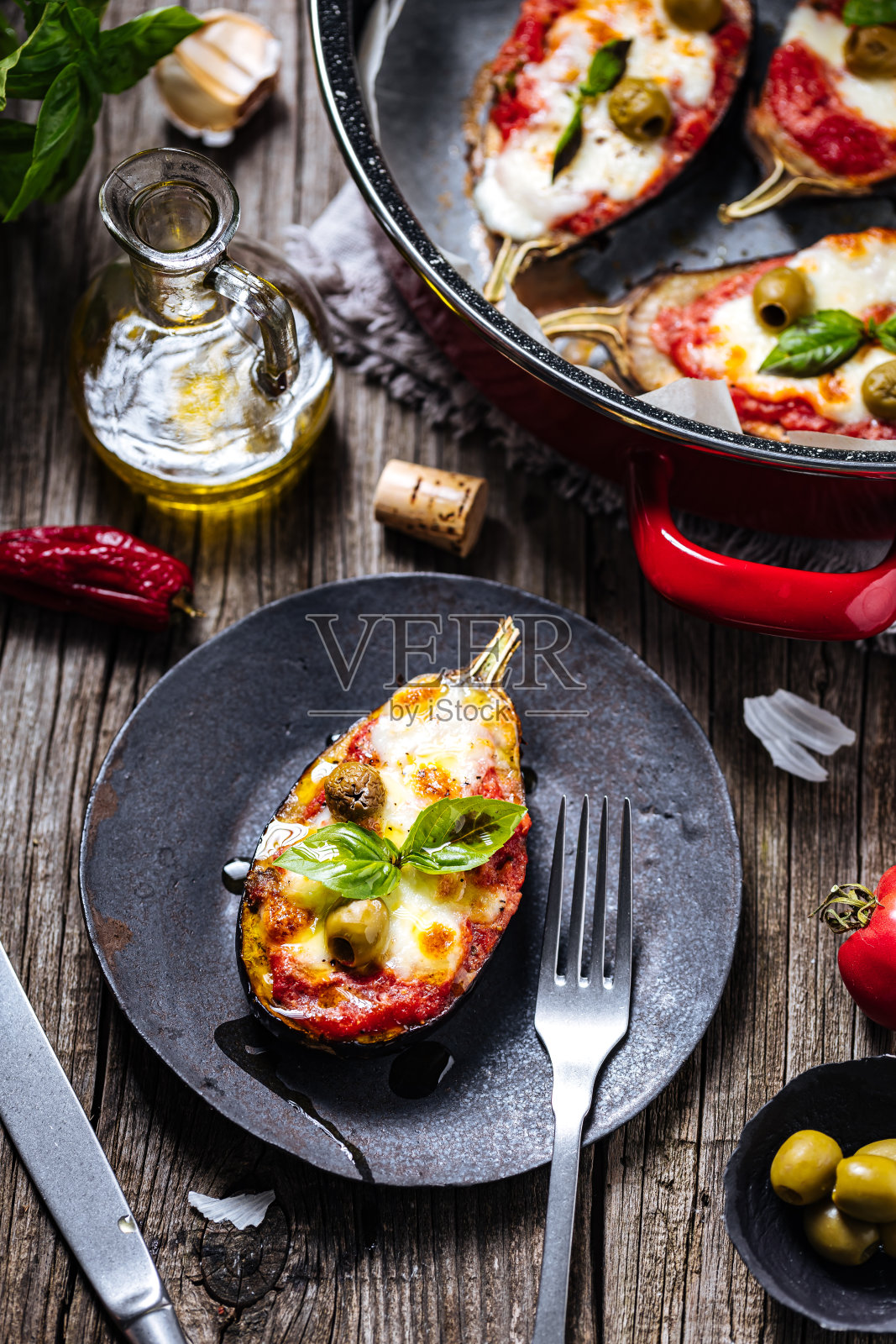 健康披萨配茄子或茄子配番茄酱、马苏里拉奶酪和罗勒叶。与食材一起放在质朴的木板上。意大利菜照片摄影图片