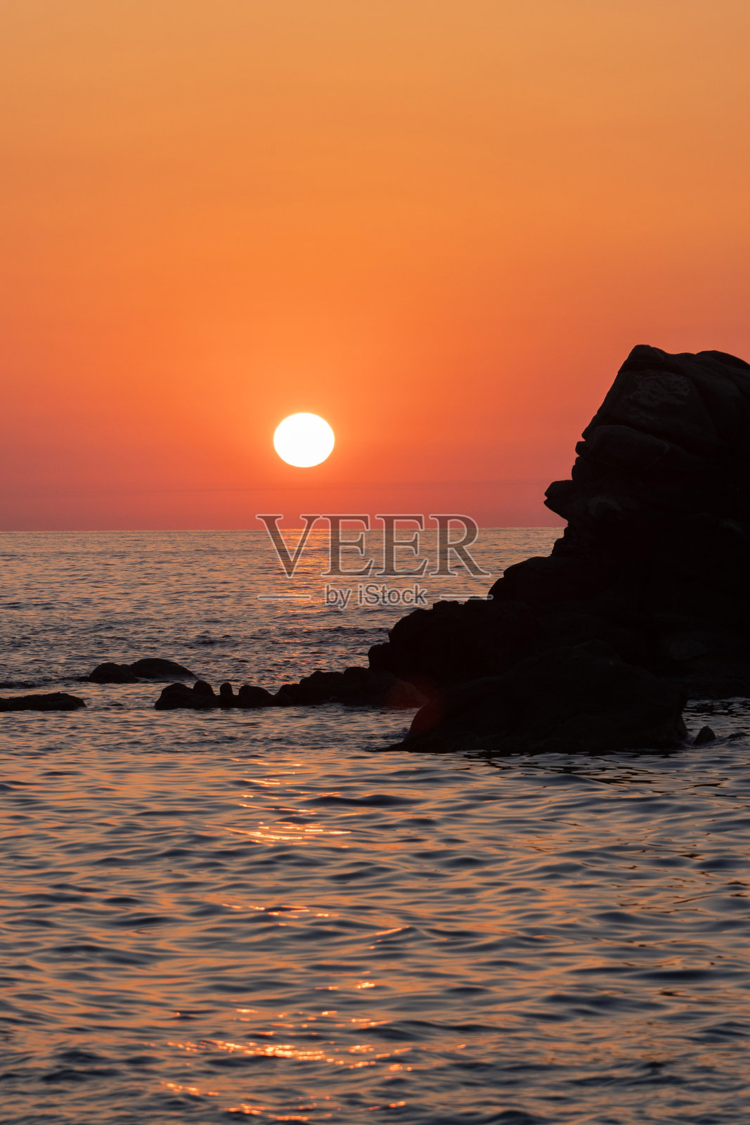 美丽的橙色日落与岩石在卡拉布里亚，地中海，意大利。热带五彩日出景观照片摄影图片