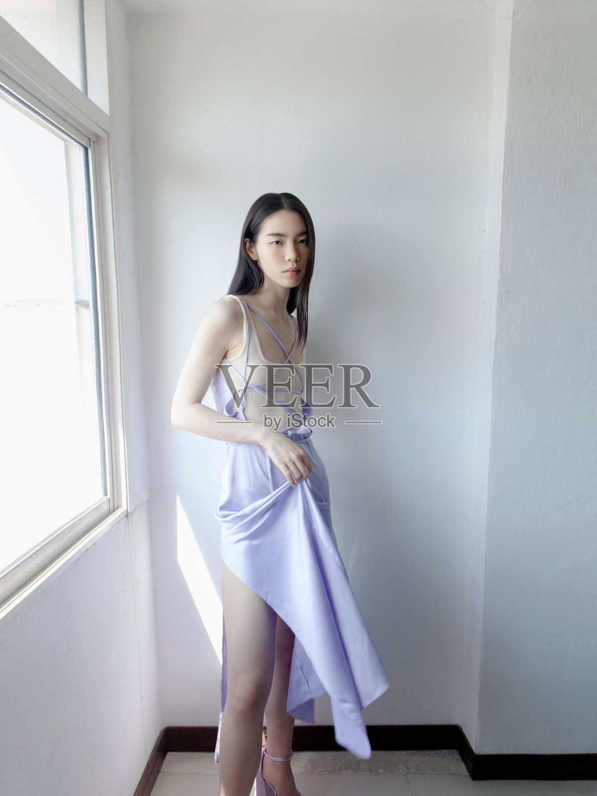 年轻美丽的亚洲女人穿着梦幻的浅紫色连衣裙和裸色顶级时装模特工作室肖像灰色背景独特的设计师服装收藏照片摄影图片