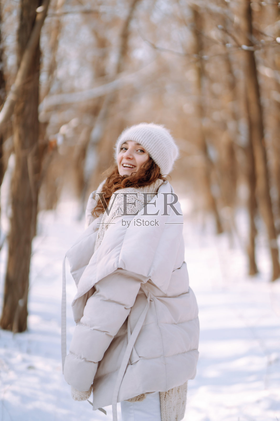 年轻女子在森林里享受着美妙的冬季气氛。照片摄影图片