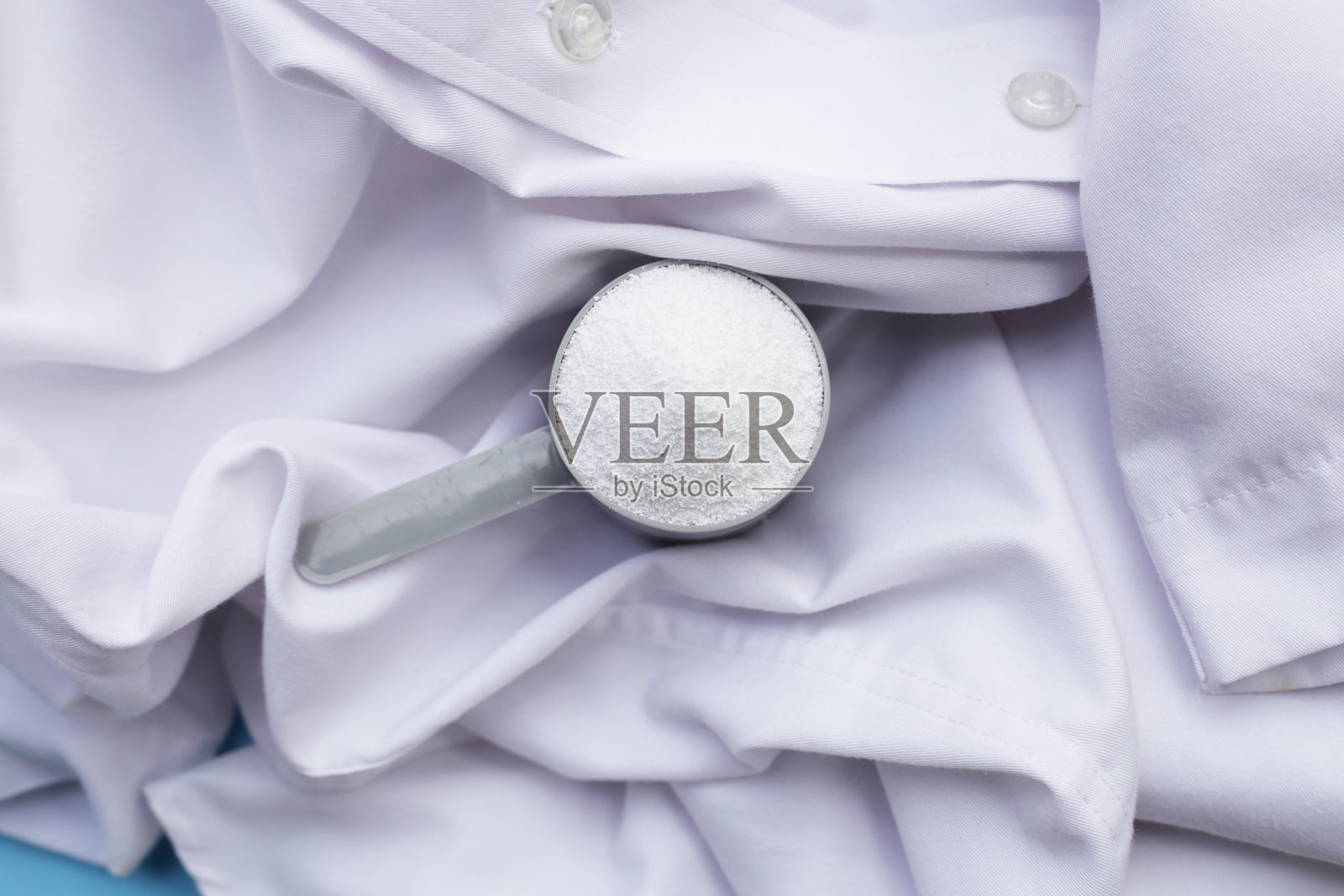 洗衣粉用量勺放在布上再洗涤。衣服的概念。照片摄影图片