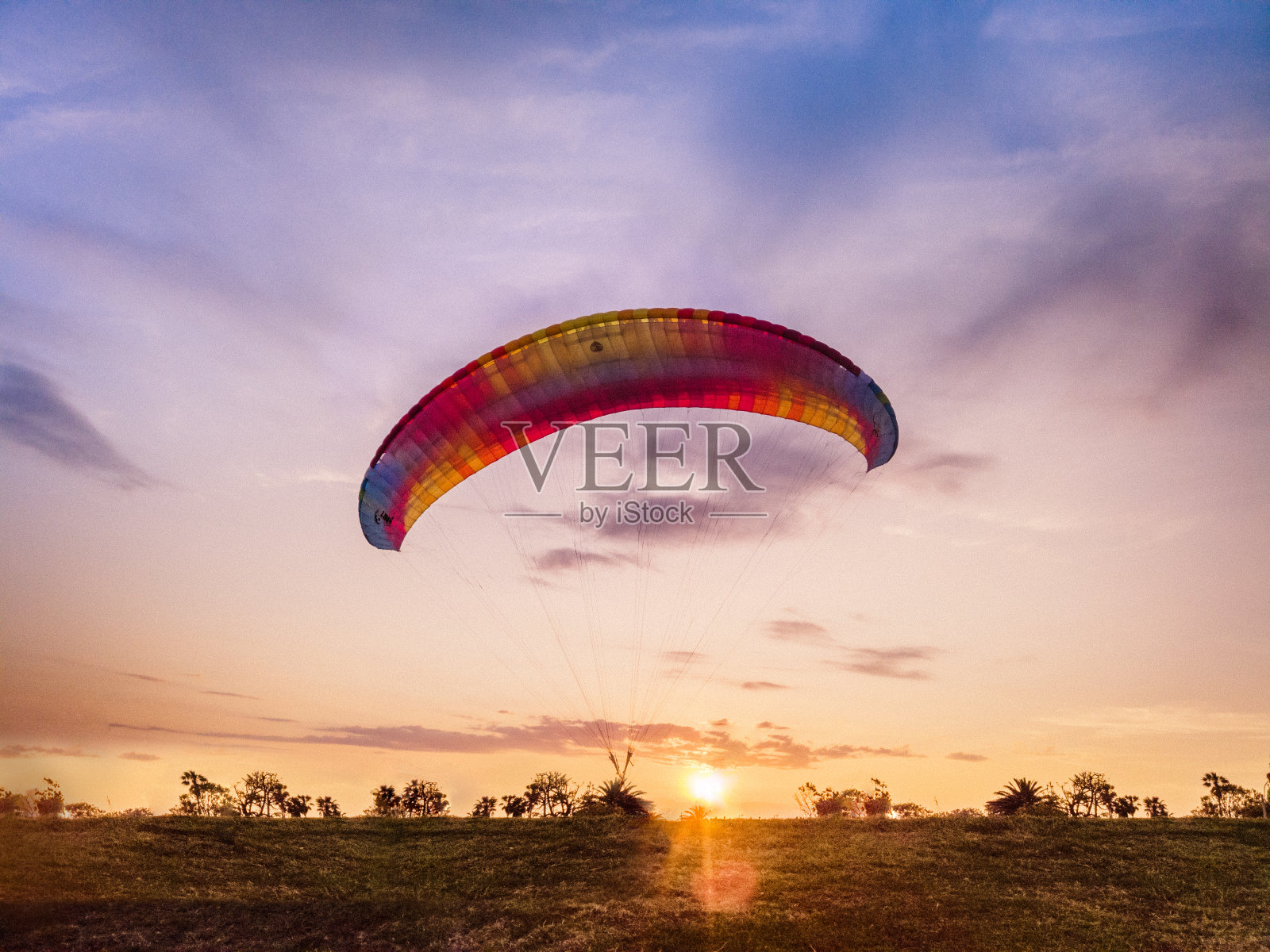 日落时滑翔伞。照片摄影图片