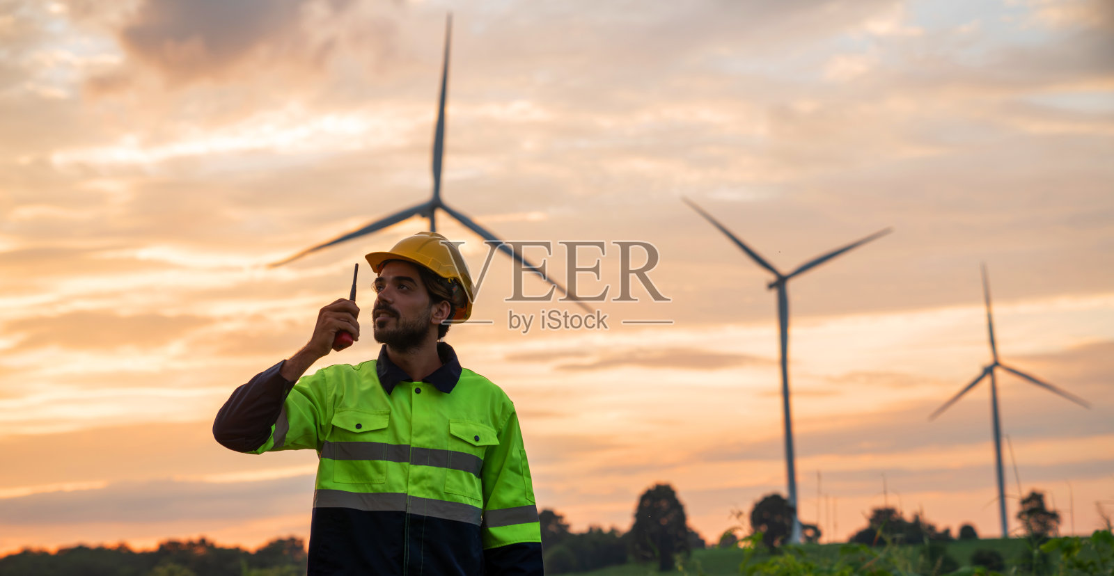 服务工程师用平板电脑检查风车系统。风力涡轮机发电。清洁和可再生能源的概念。照片摄影图片