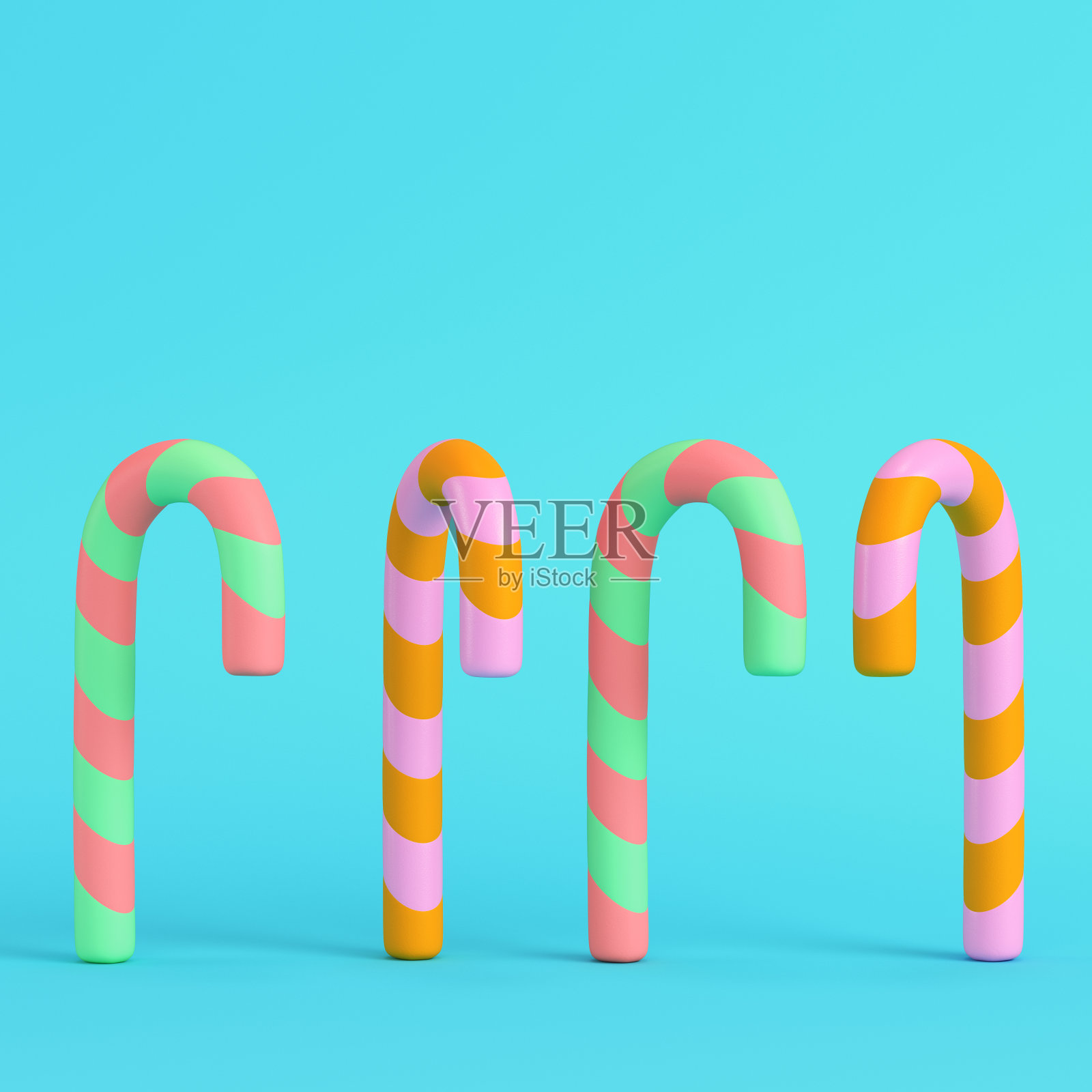 四个彩色拐杖糖在明亮的蓝色背景在柔和的颜色照片摄影图片