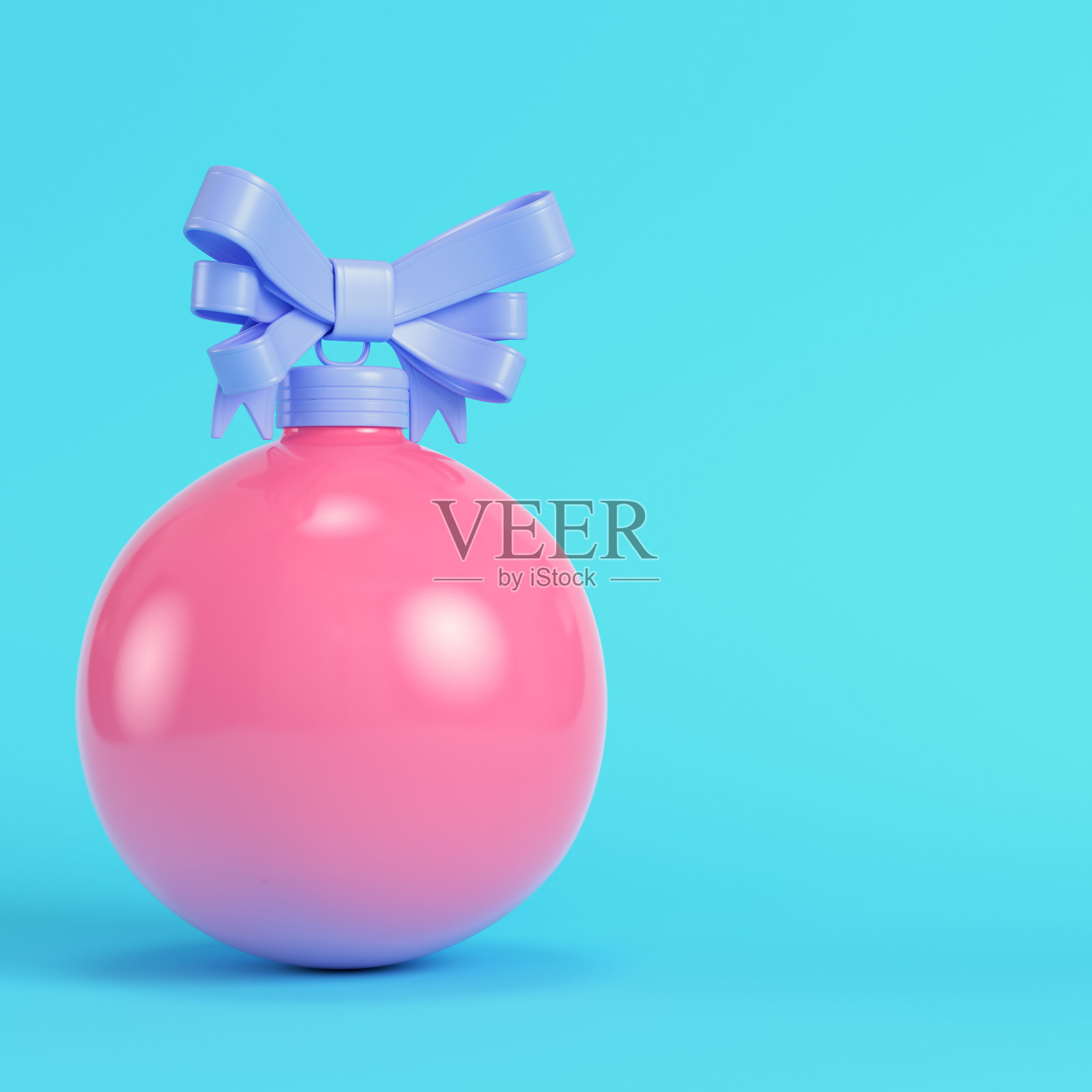 粉红色圣诞气泡与一个蝴蝶结上明亮的蓝色背景在柔和的颜色照片摄影图片