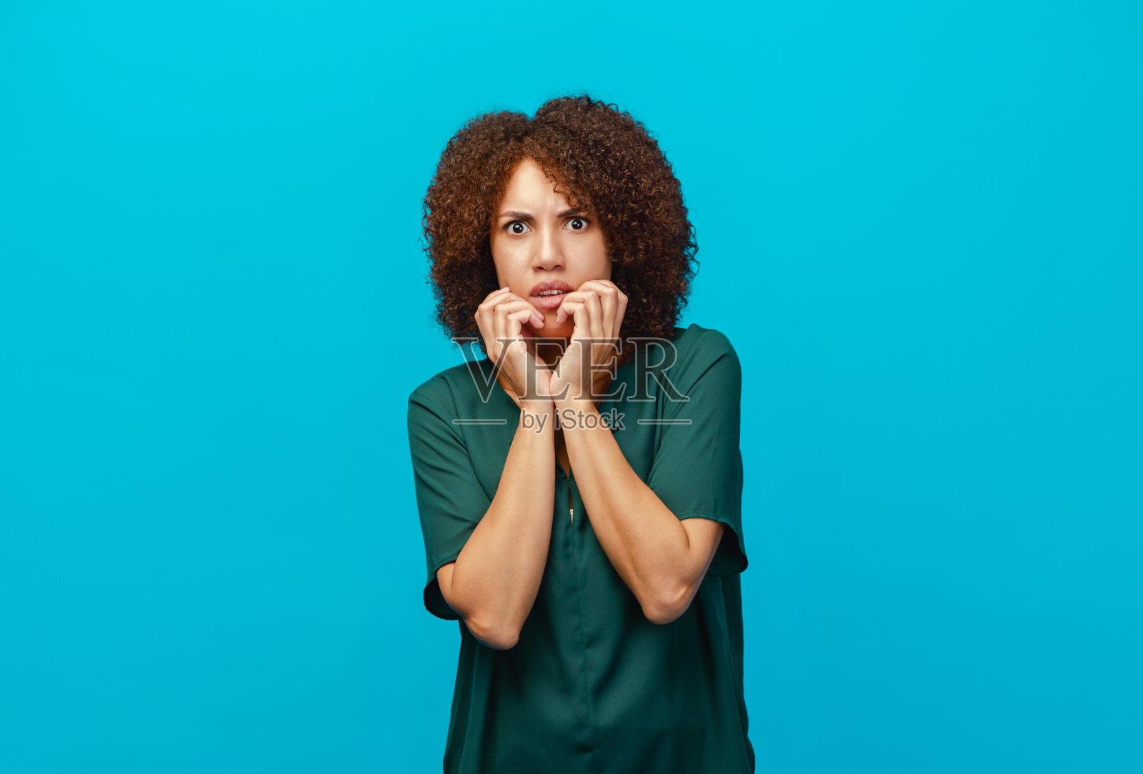 惊恐的女人带着恐惧的情绪孤立地站在蓝色的背景上照片摄影图片
