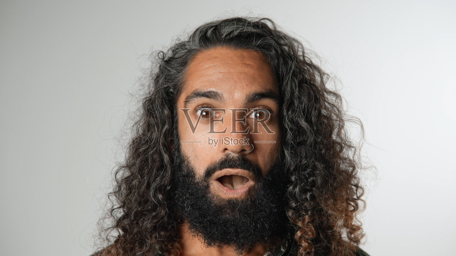 长着卷发的惊讶男人。快乐的家伙脸画像。英俊的人。照片摄影图片