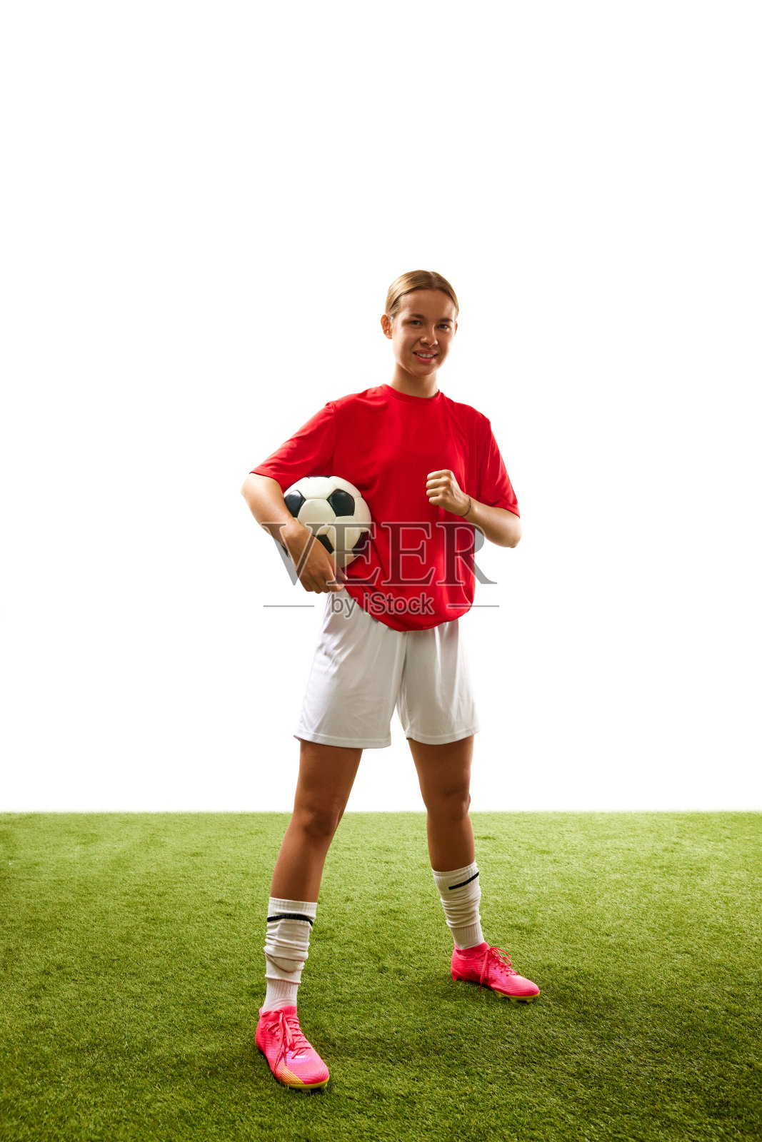 全身的年轻女子，足球运动员穿着制服站在草地上的球孤立的白色背景照片摄影图片