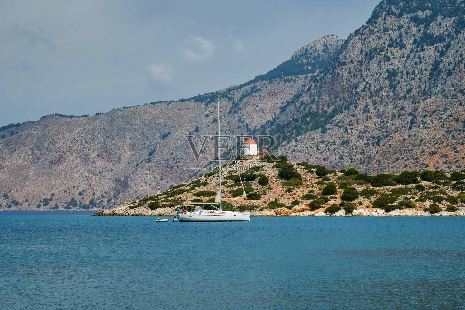海湾和风车的景色，下面停泊着一艘游艇，希腊西米岛照片摄影图片