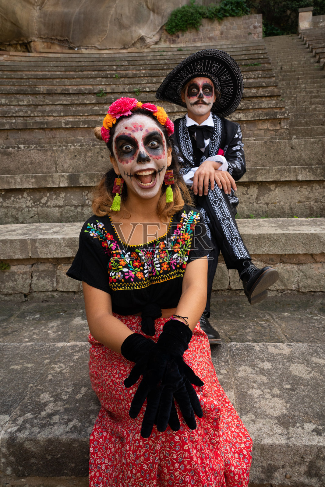 一对夫妇在亡灵节打扮成优雅的墨西哥女神。有趣的脸照片摄影图片