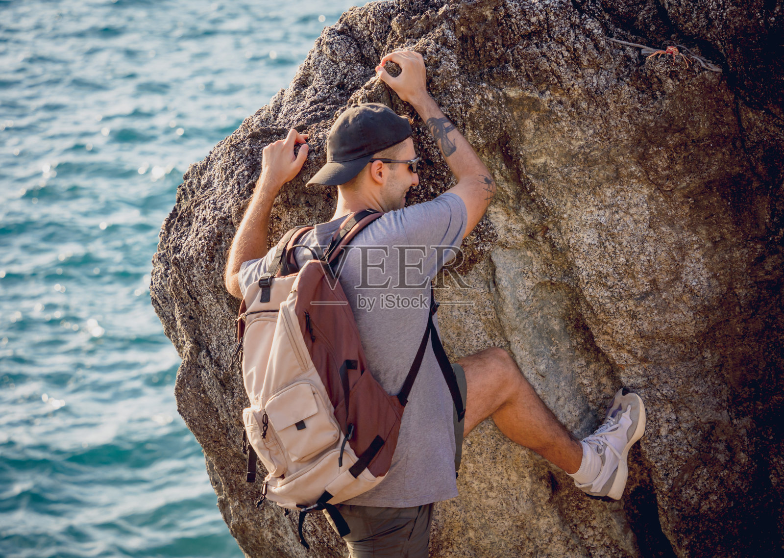 一个年轻人爬到靠近大海的山上照片摄影图片