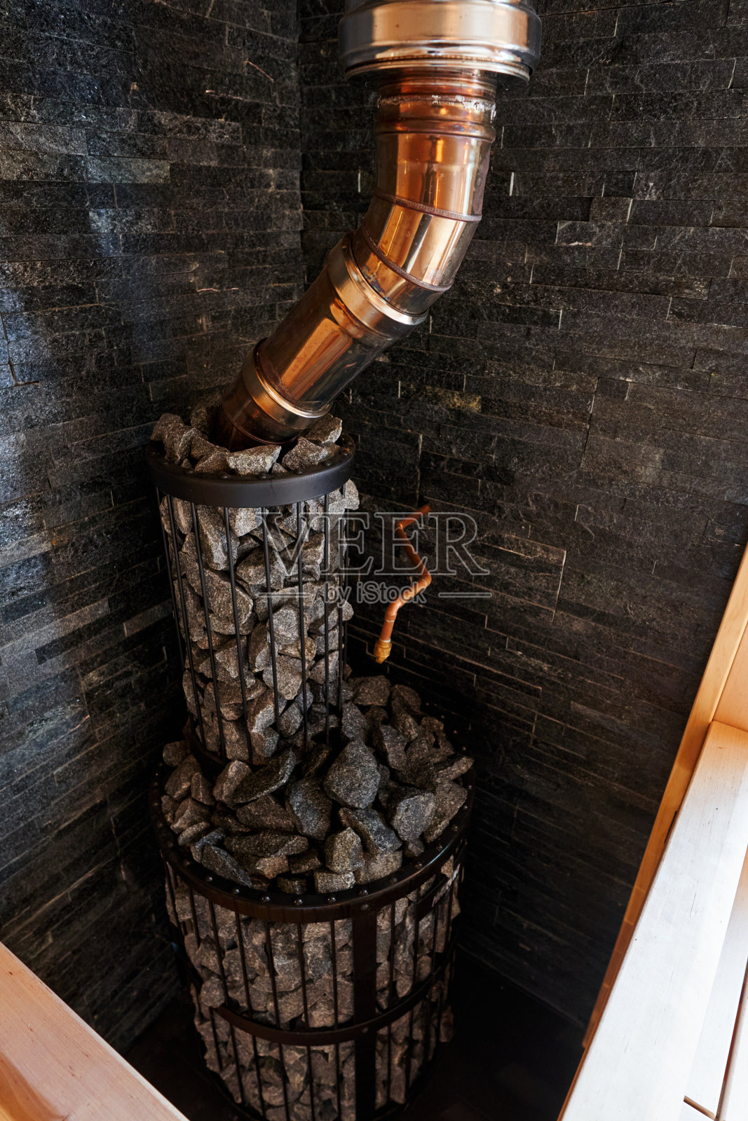 带烟囱的金属网炉子，桑拿房里堆满了石头照片摄影图片