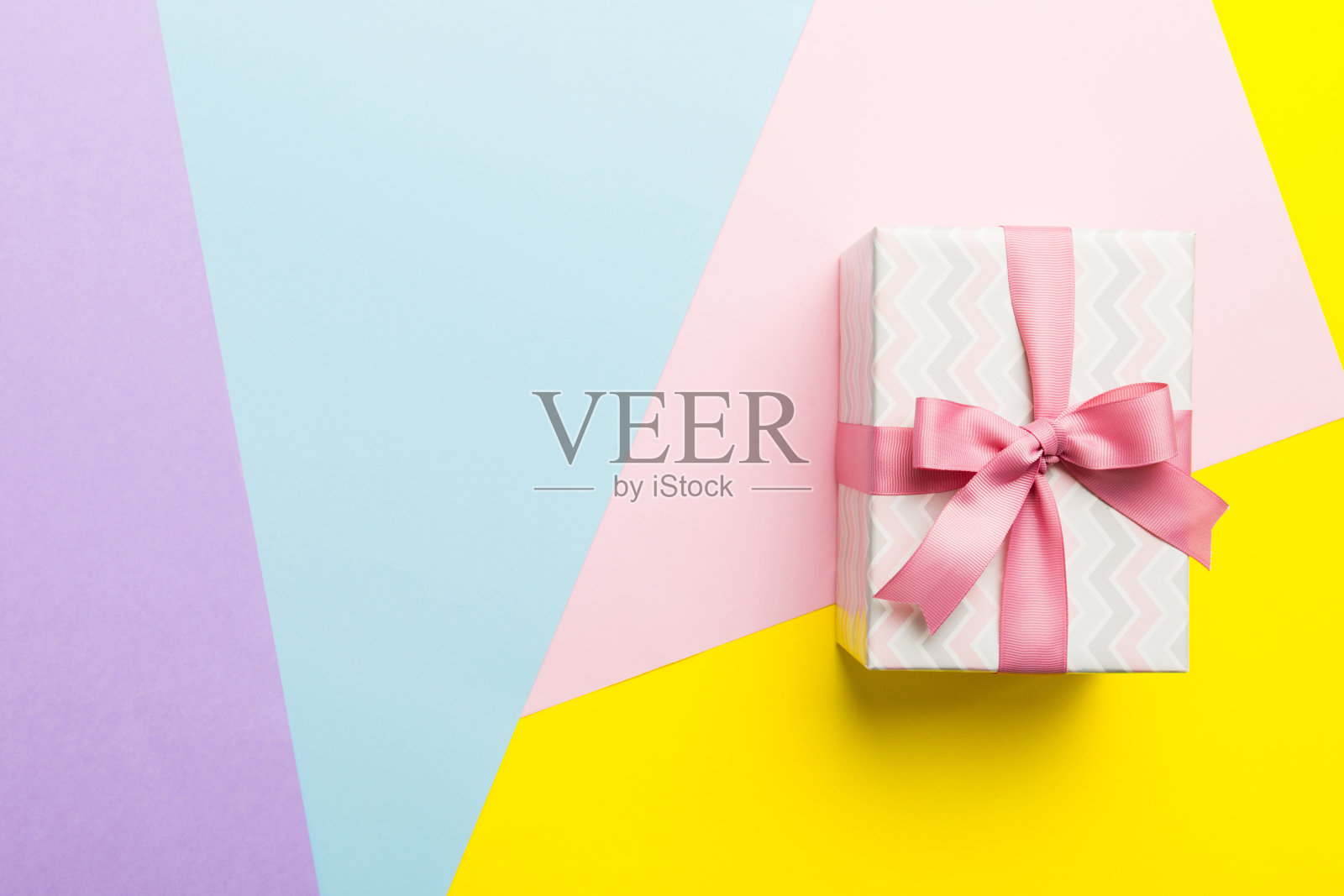 节日纸礼物系粉红色丝带蝴蝶结顶部视图与复制空间。平铺假日背景。生日或圣诞礼物。圣诞礼盒概念与复制空间照片摄影图片