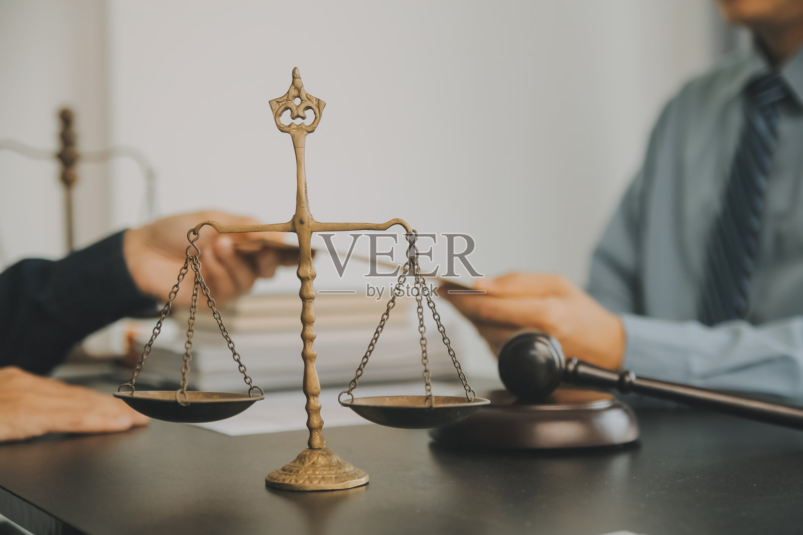 商务人士和律师们在办公室的桌子上用黄铜秤讨论合同文件。法律、法律服务、法律咨询、司法和法律概念图片具有膜纹效果照片摄影图片
