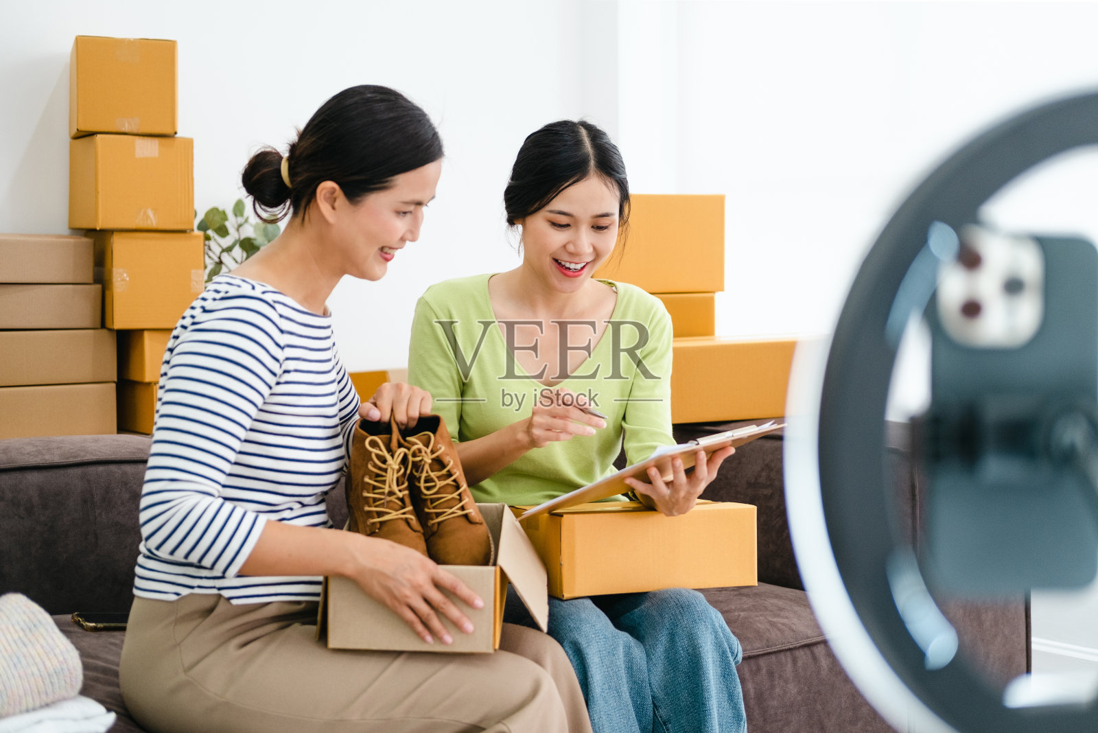 美女在家在社交网络上评论产品和会说话的相机直播视频，在社交媒体上在线销售衣服照片摄影图片