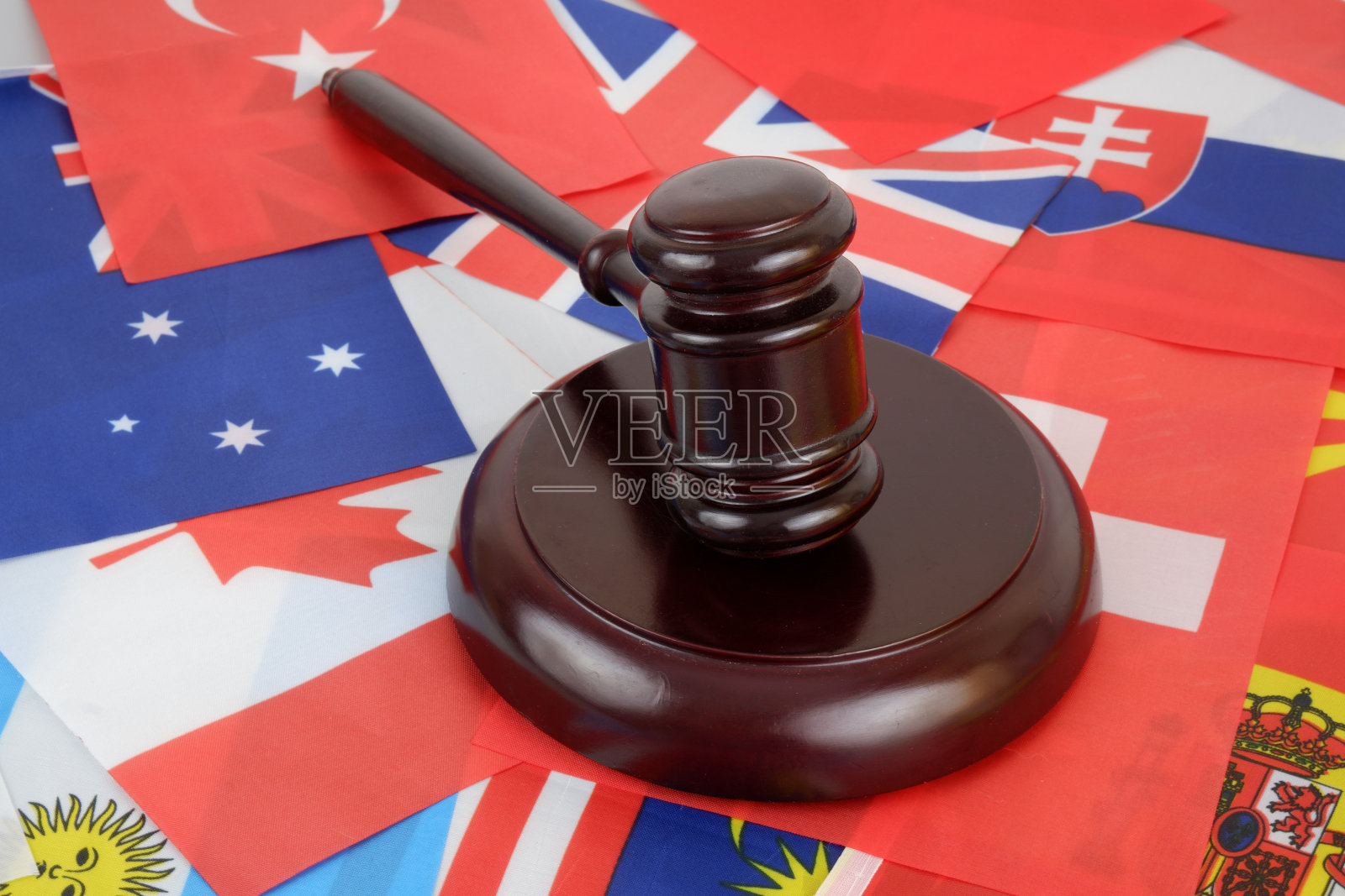 法官在许多旗帜的背景上敲木槌。照片摄影图片
