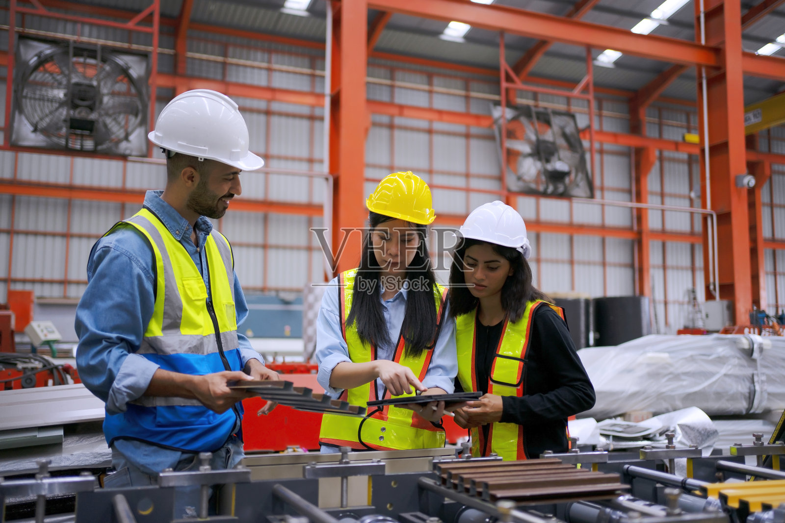在金属片厂工作的蓝领工人。照片摄影图片