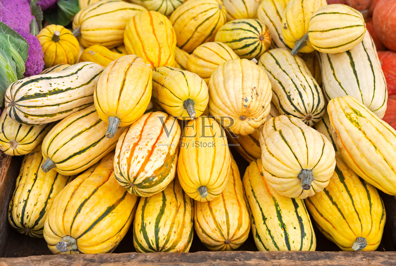 在当地的农贸市场，一堆圆柱形的熟食南瓜照片摄影图片