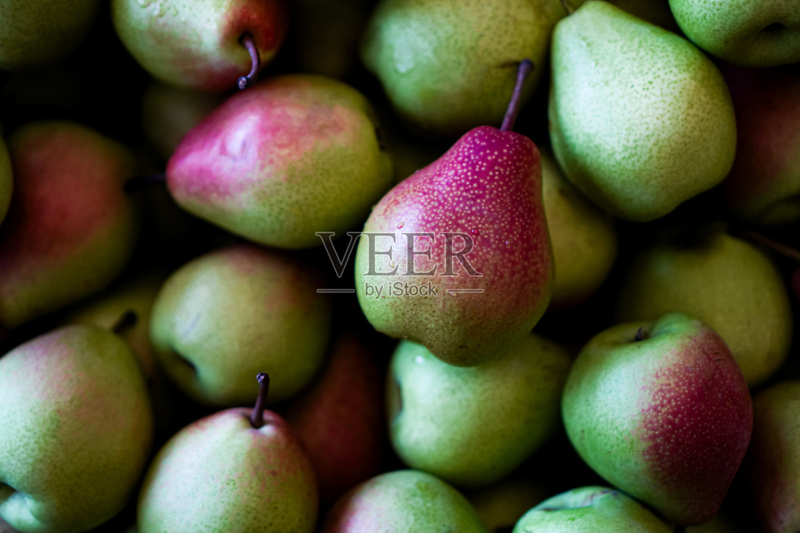 水果桌上一堆梨子的特写。照片摄影图片