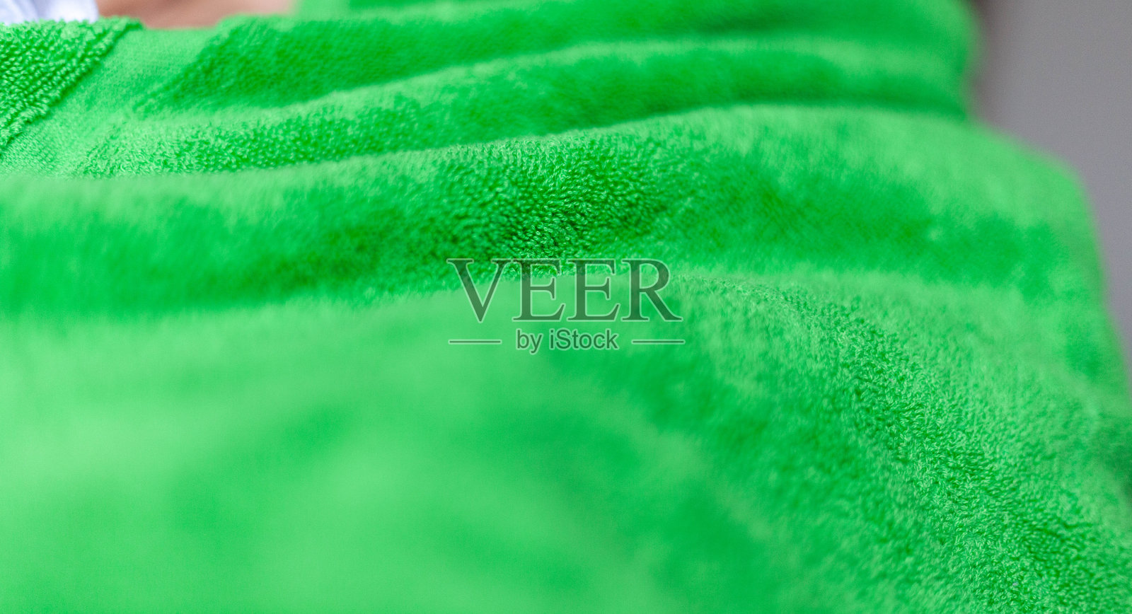 皱巴巴的浅绿色超细纤维布作为背景，特写照片。照片摄影图片