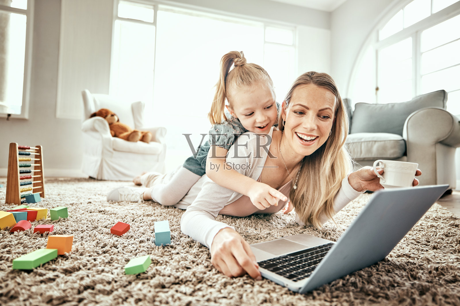 母亲，孩子和笔记本电脑用于家庭游戏，电子学习和快乐的视频流或客厅地毯上的教育。妈妈，家人和女孩在地板和电脑上玩孩子的网站或在线学校照片摄影图片