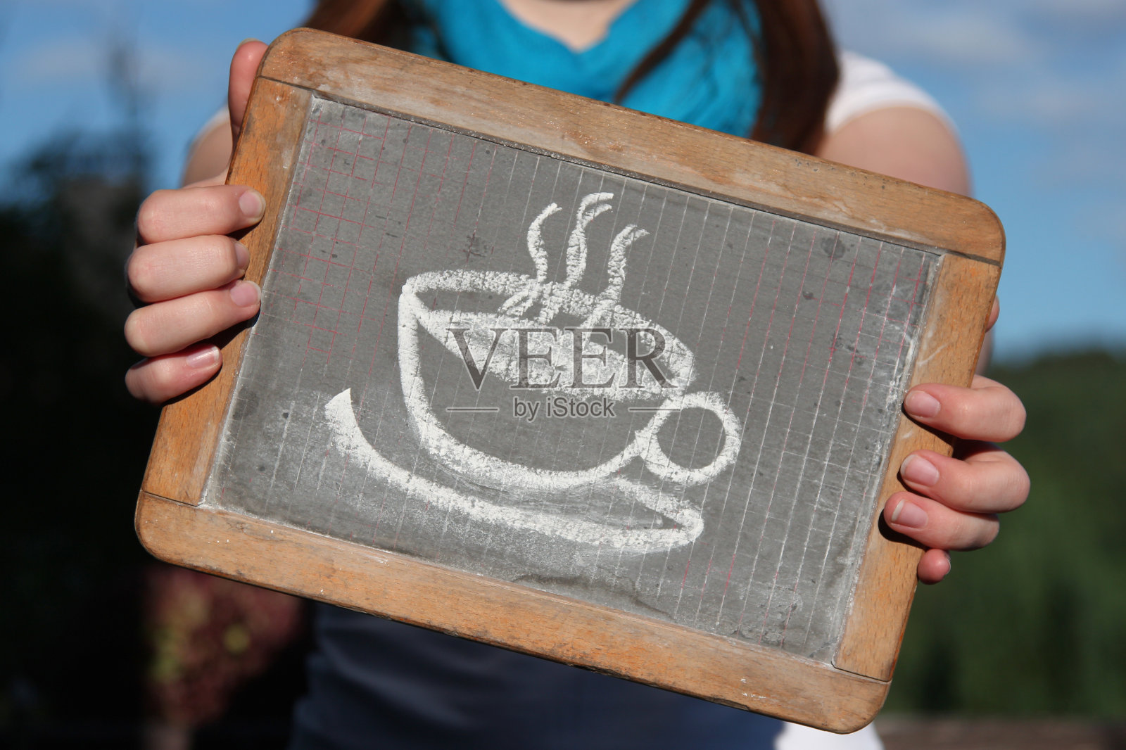 年轻女性在石板上用粉笔画的咖啡杯照片摄影图片