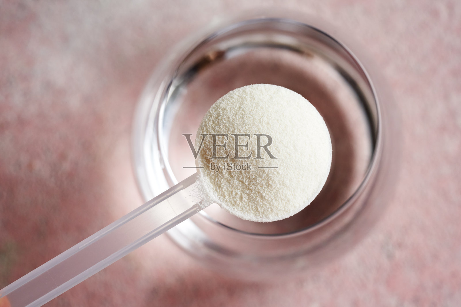 胶原蛋白粉用塑料勺舀入一杯水照片摄影图片