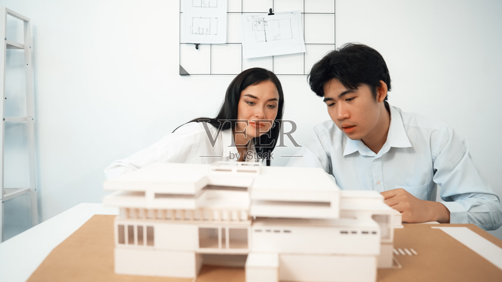 熟练的建筑工程师团队检查并确定房屋模型。完美的。照片摄影图片