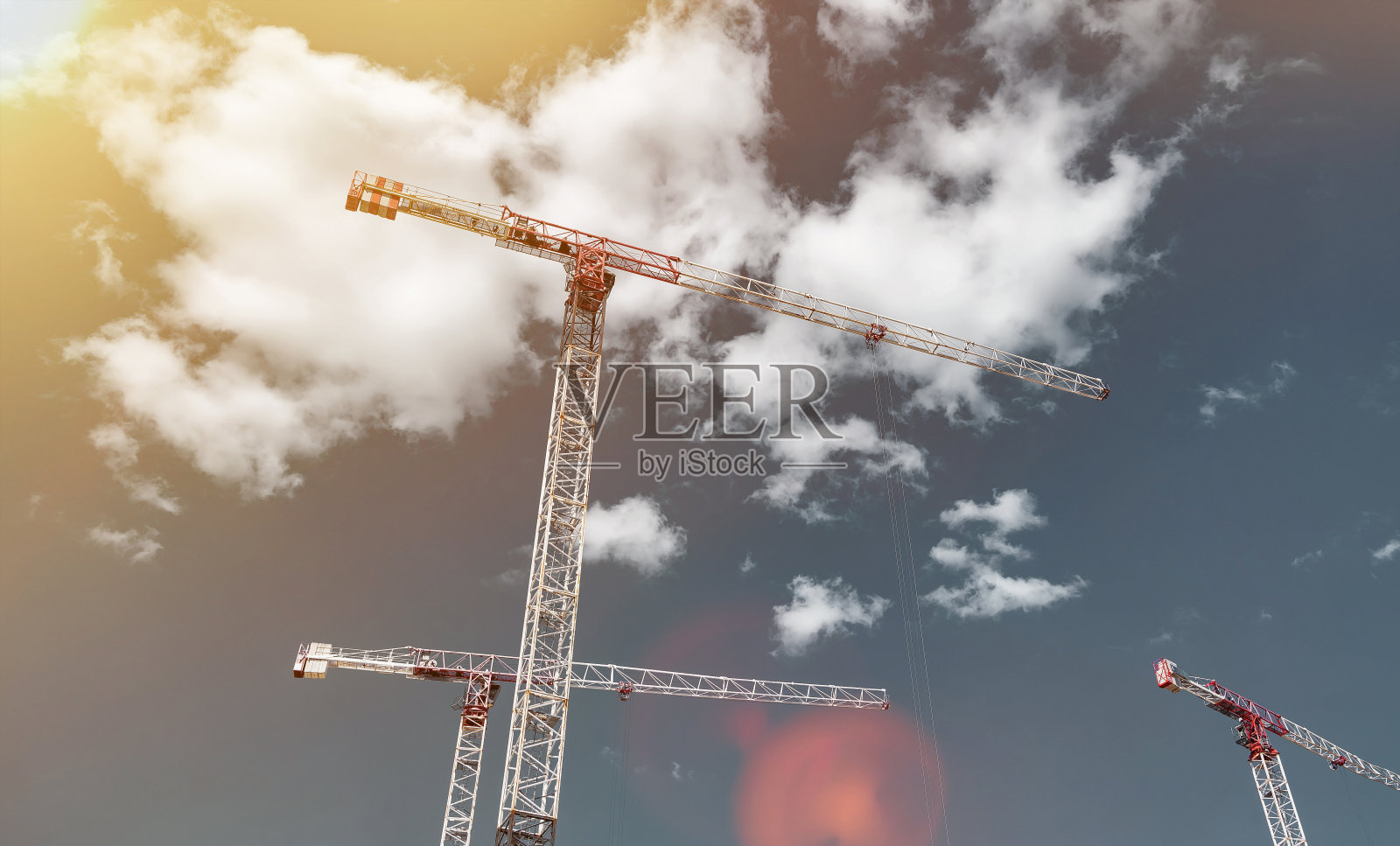 建筑起重机在创作现场工作，蓝天为背景照片摄影图片