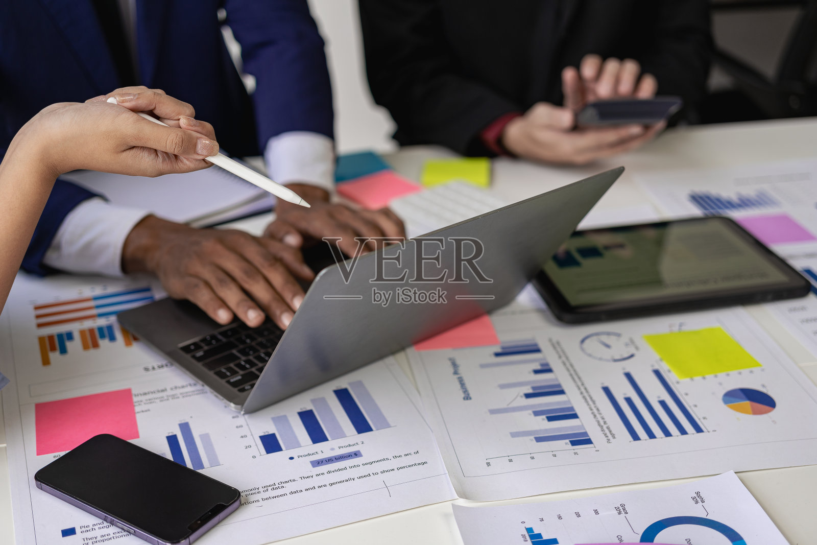 一群自信的年轻商人在讨论财务数据分析和商业战略项目的协作会议上使用电脑分析数据。照片摄影图片