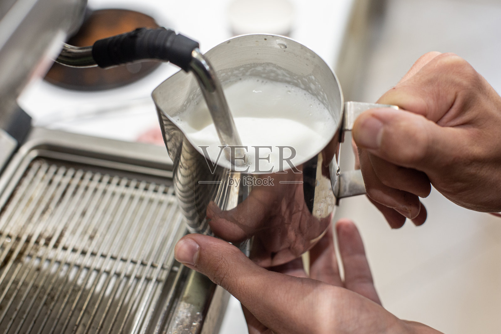 在咖啡店里，咖啡师正在煮一杯牛奶照片摄影图片