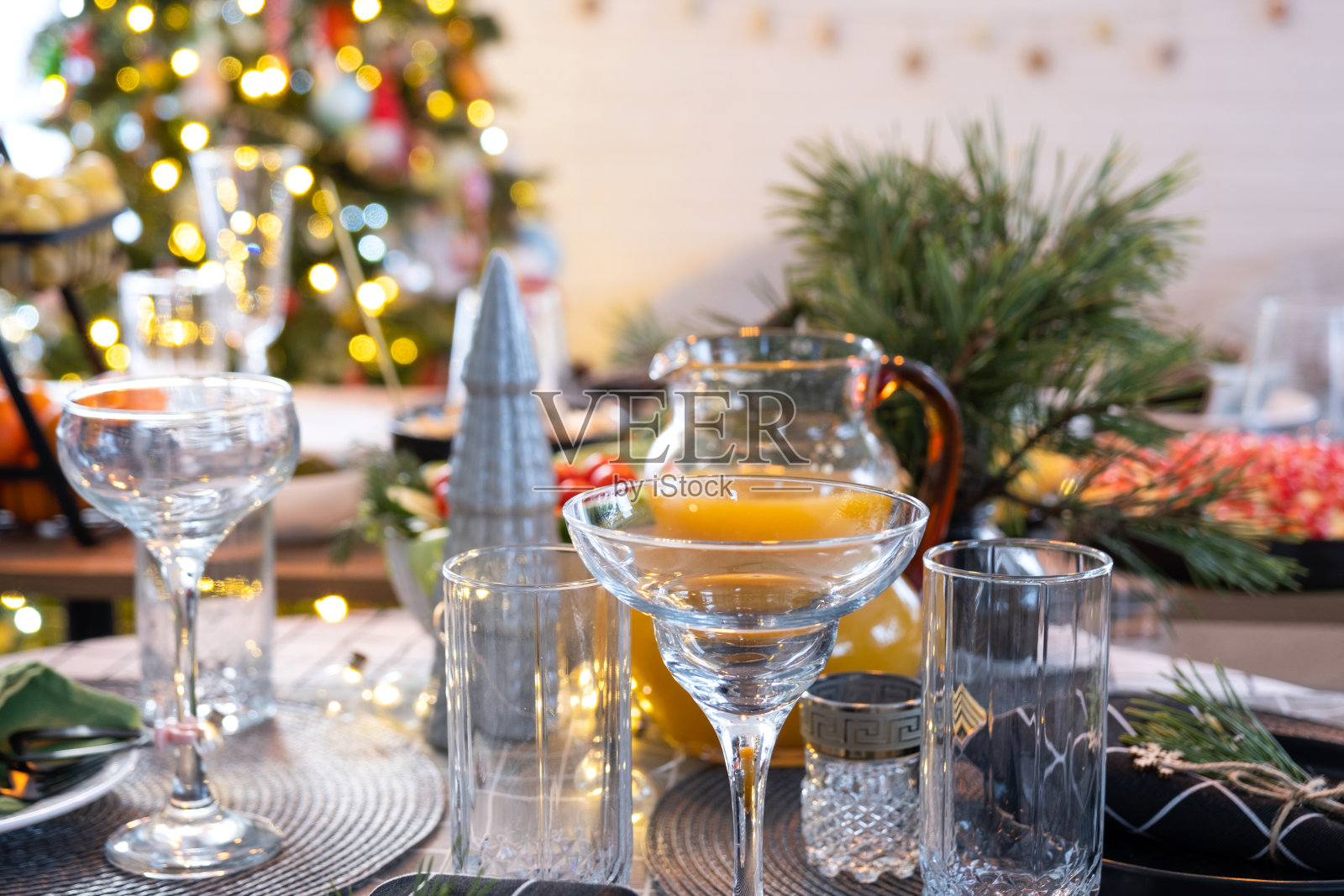 在圣诞节和新年装饰的阁楼房子的现代内部，为节日餐桌提供小吃、沙拉和糖果。等待客人参加节日晚宴照片摄影图片