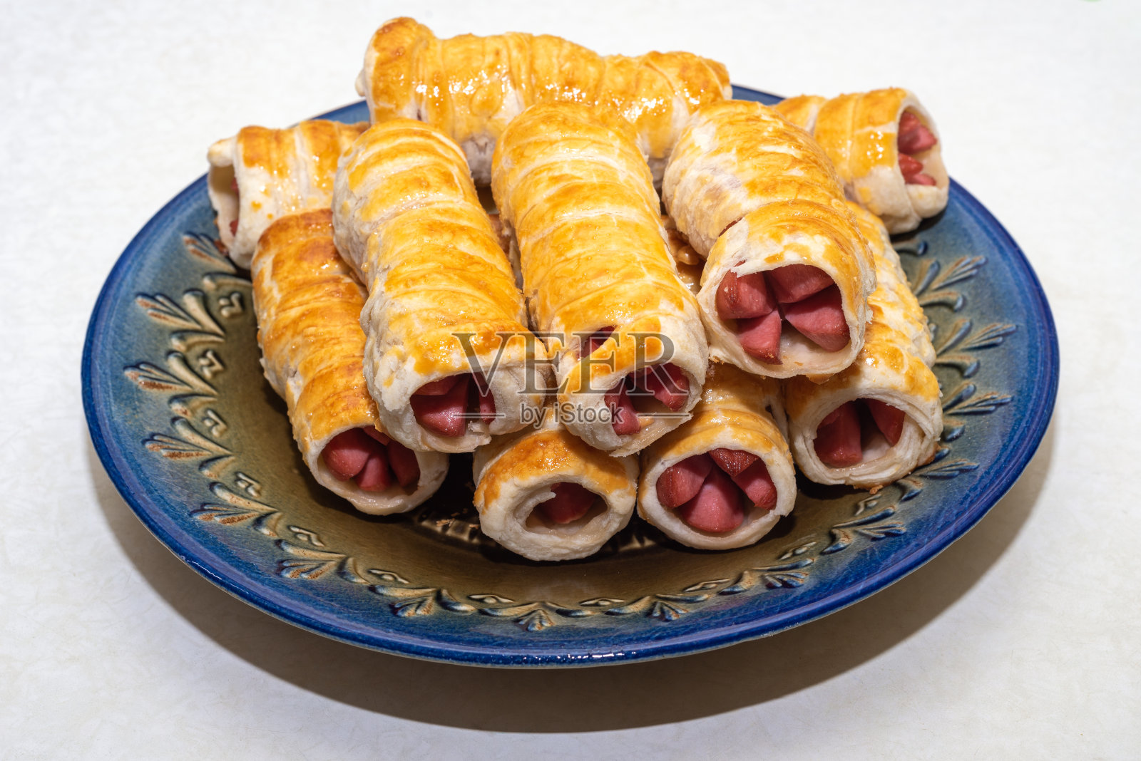 一盘满是新鲜出炉的多汁香肠的糕点。照片摄影图片