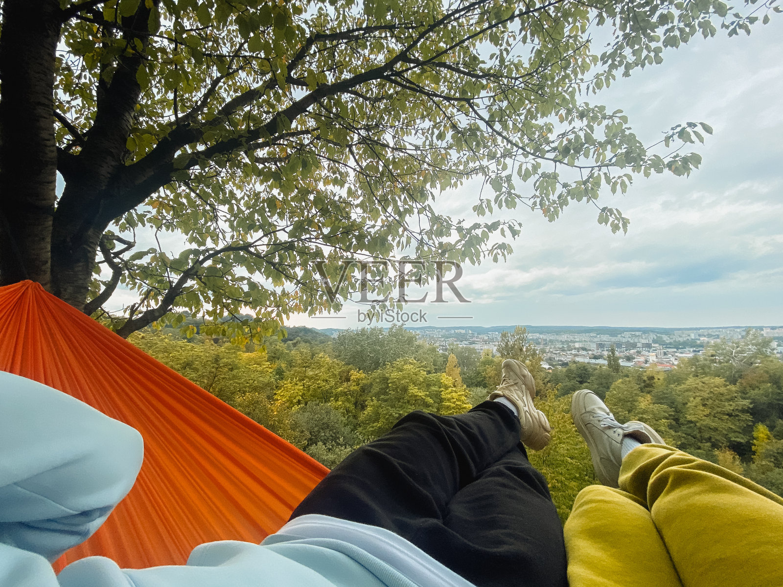 一对夫妇躺在吊床上放松，享受着温暖的秋日照片摄影图片