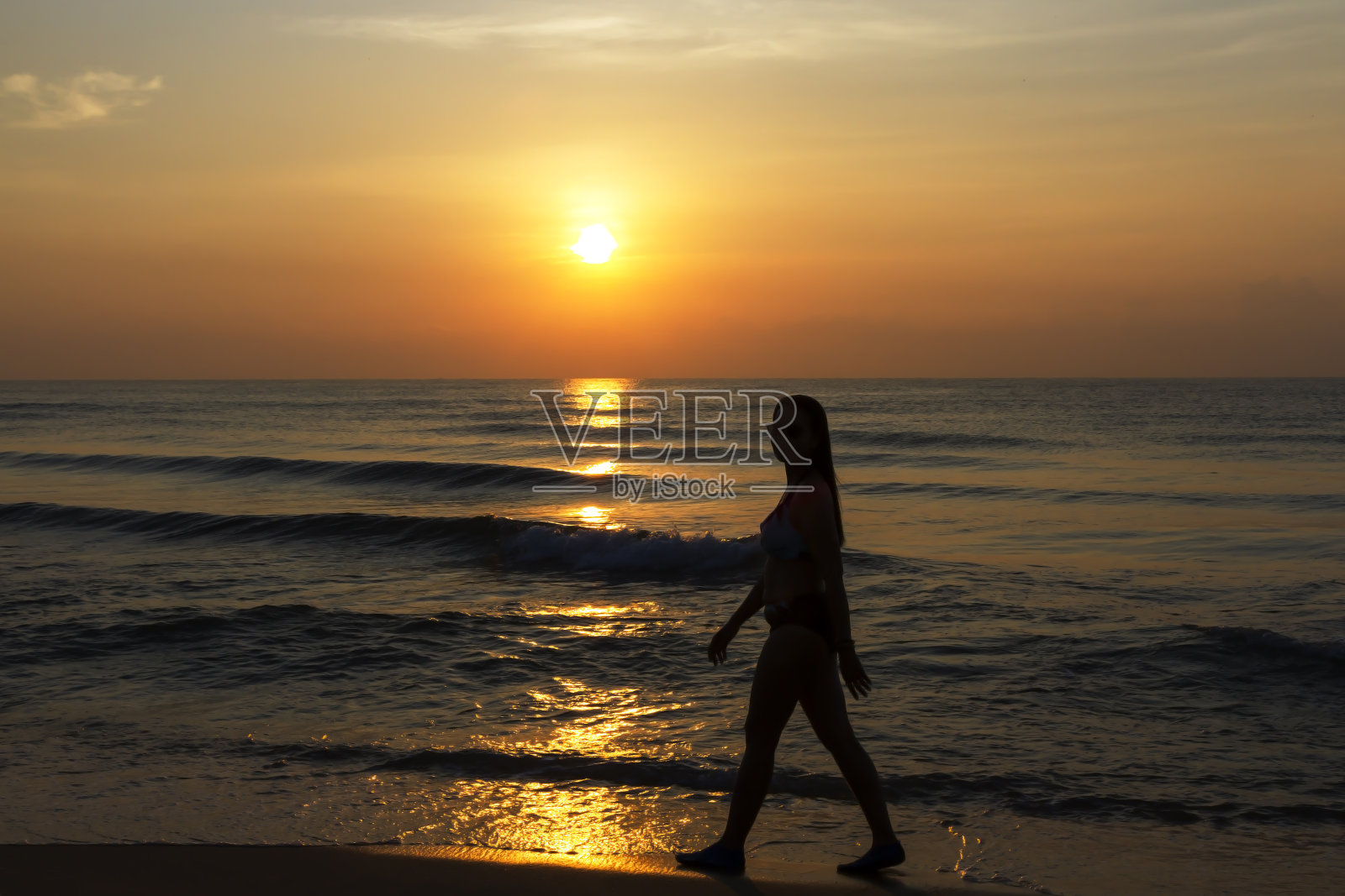 穿着比基尼的大女人和沙滩上的日出照片摄影图片