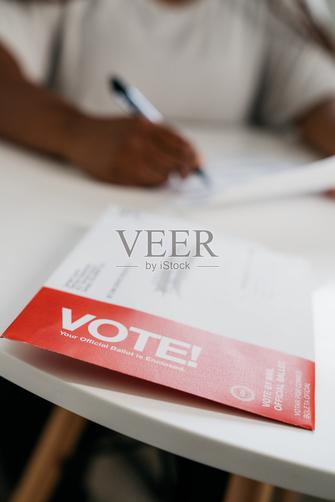 “投票!”信封的肖像，上面是黑人妇女在家里填写总统、参议院、国会或地方选举的邮寄选票照片摄影图片