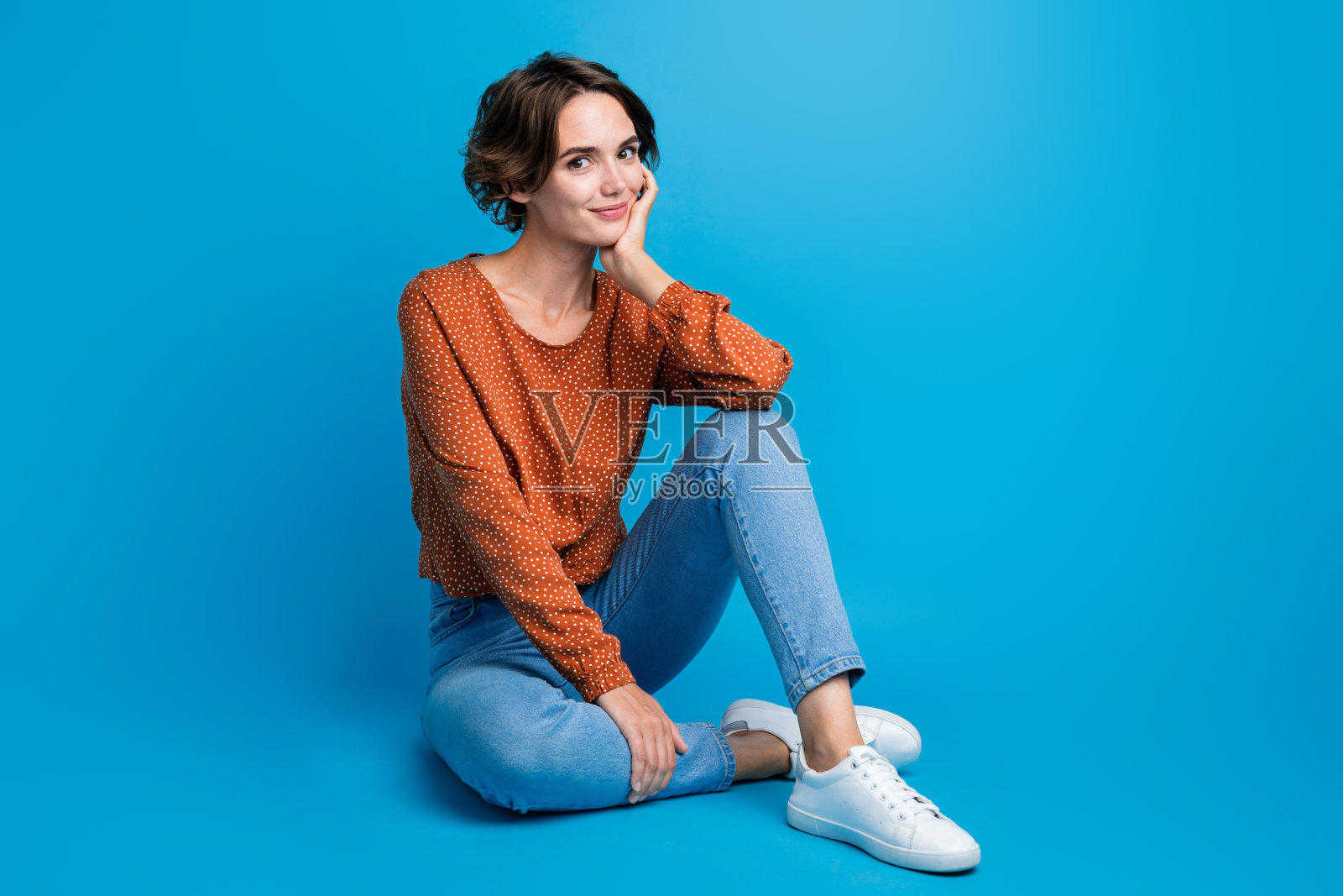迷人的年轻女士的全尺寸照片坐在地板上穿着凉爽的衣服收集休闲服装孤立的蓝色背景照片摄影图片