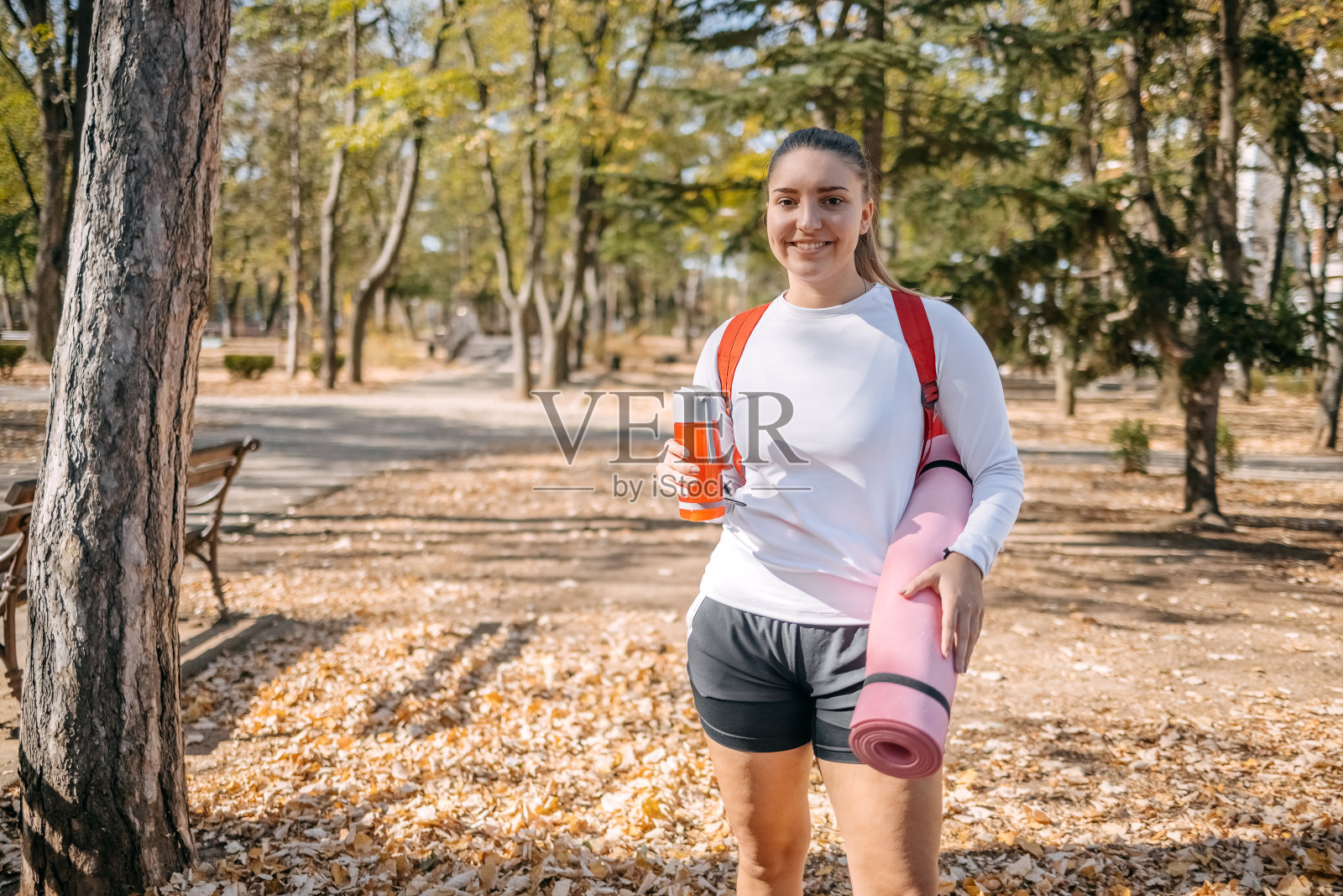 年轻女子手持运动垫上健身课的照片照片摄影图片
