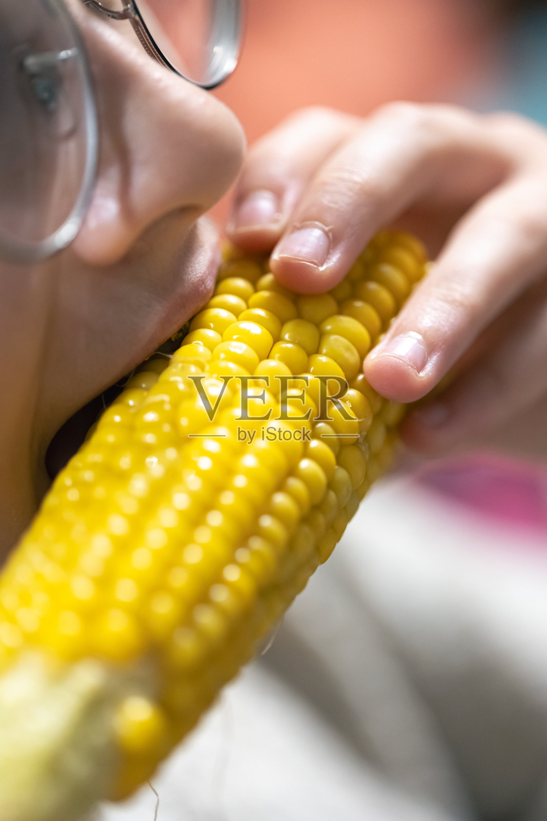 一个女孩吃玉米的详细照片。照片摄影图片