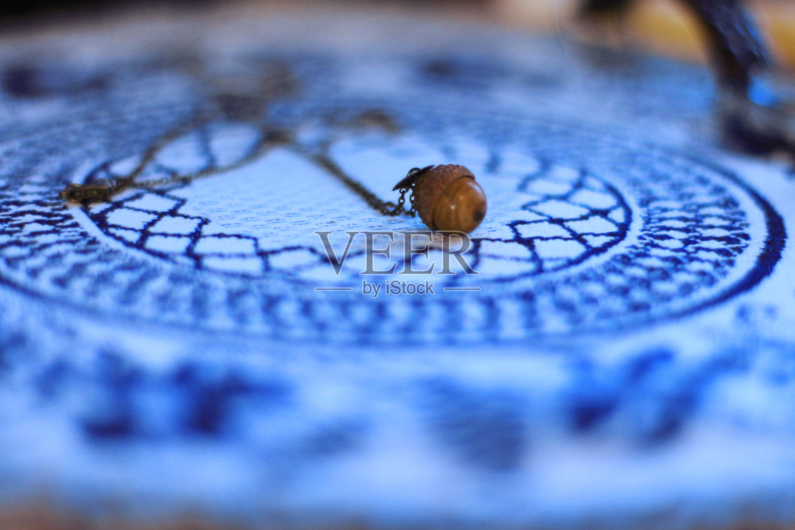 橡子形状的手工女性珠宝垂饰放在绣花餐巾上照片摄影图片