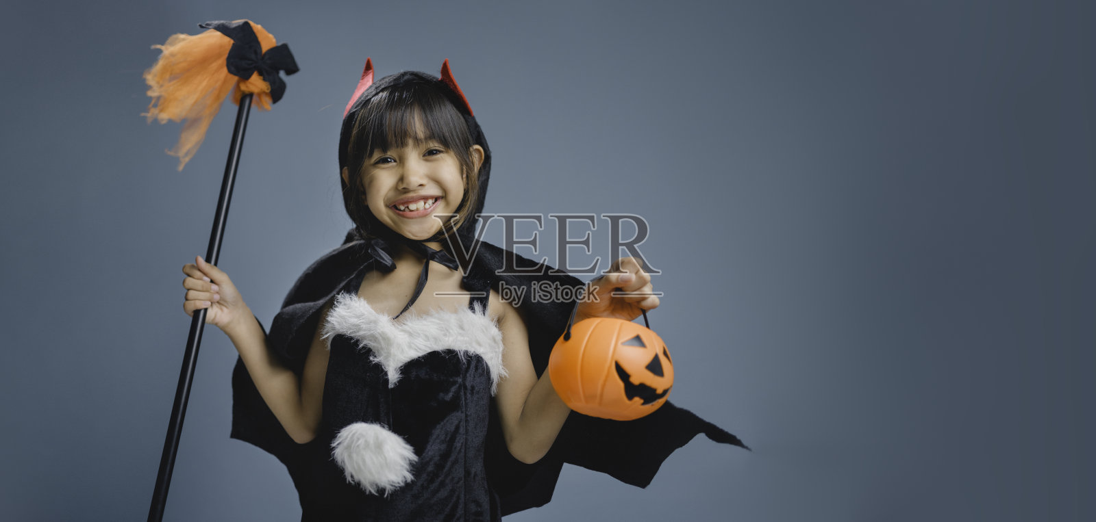 一个小女孩穿着巫婆的万圣节服装。照片摄影图片