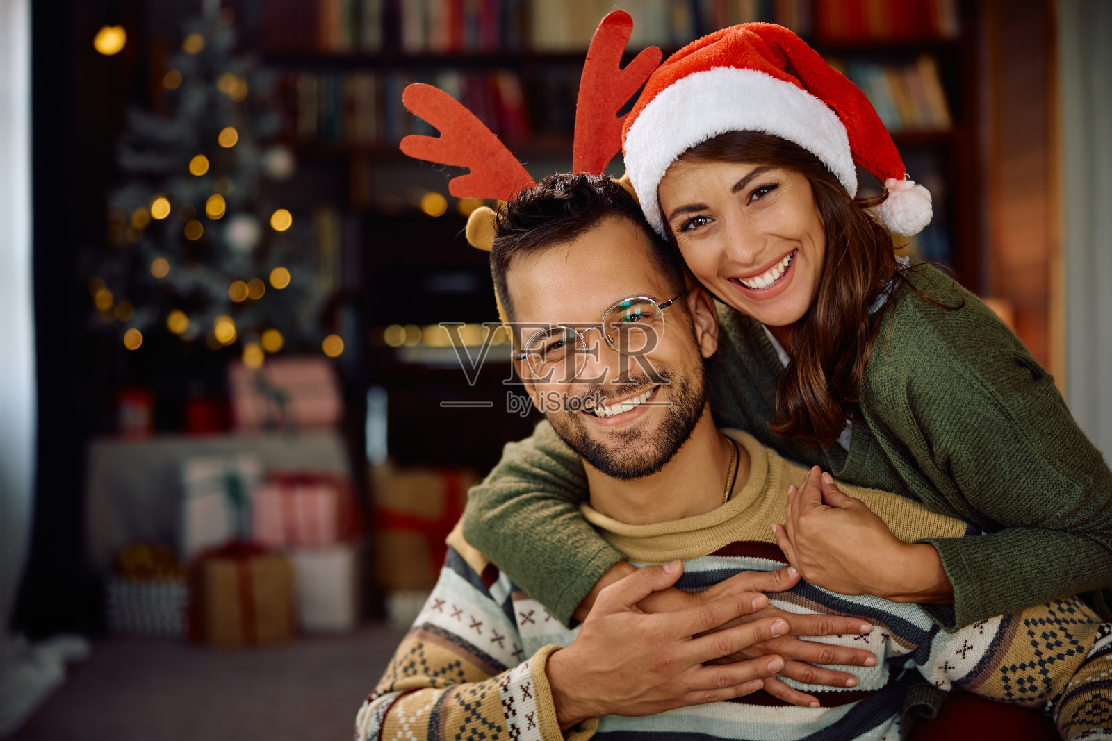 幸福的夫妇在圣诞节在家里看着相机的肖像。照片摄影图片