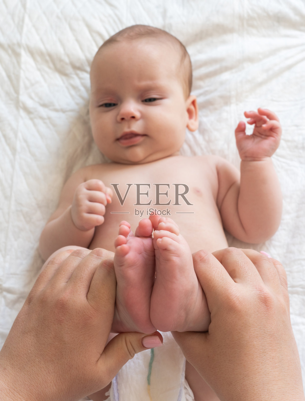 把婴儿的脚放在母亲的手里安慰。便秘缓解技术的概念照片摄影图片