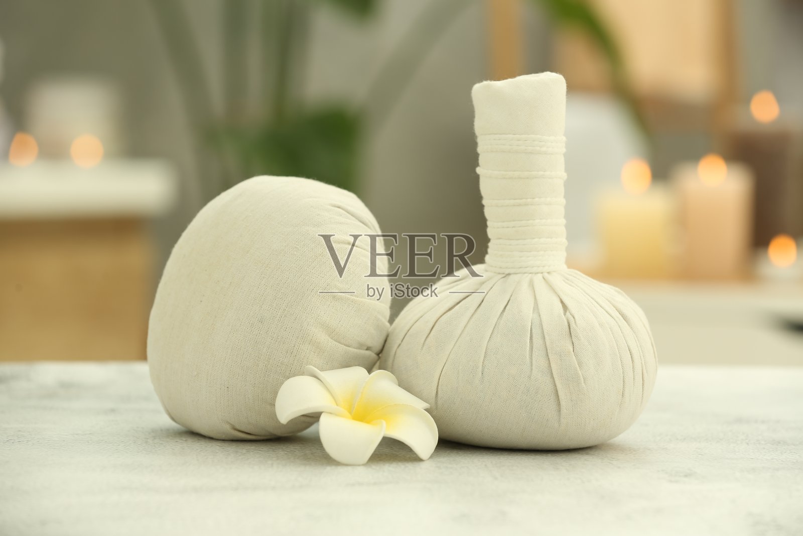 美丽的水疗组成与草药按摩袋和鸡蛋花在浅灰色的桌子上的健康中心照片摄影图片