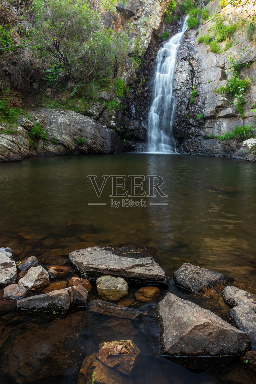 田园诗般的湖泊景观与瀑布和岩石在前景在佩内多富拉多在维拉德雷，葡萄牙。照片摄影图片