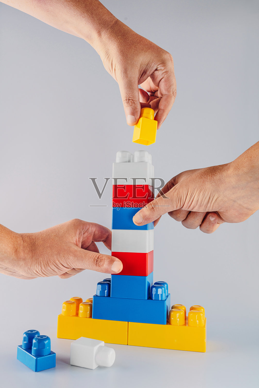 用手用彩色积木搭塔照片摄影图片