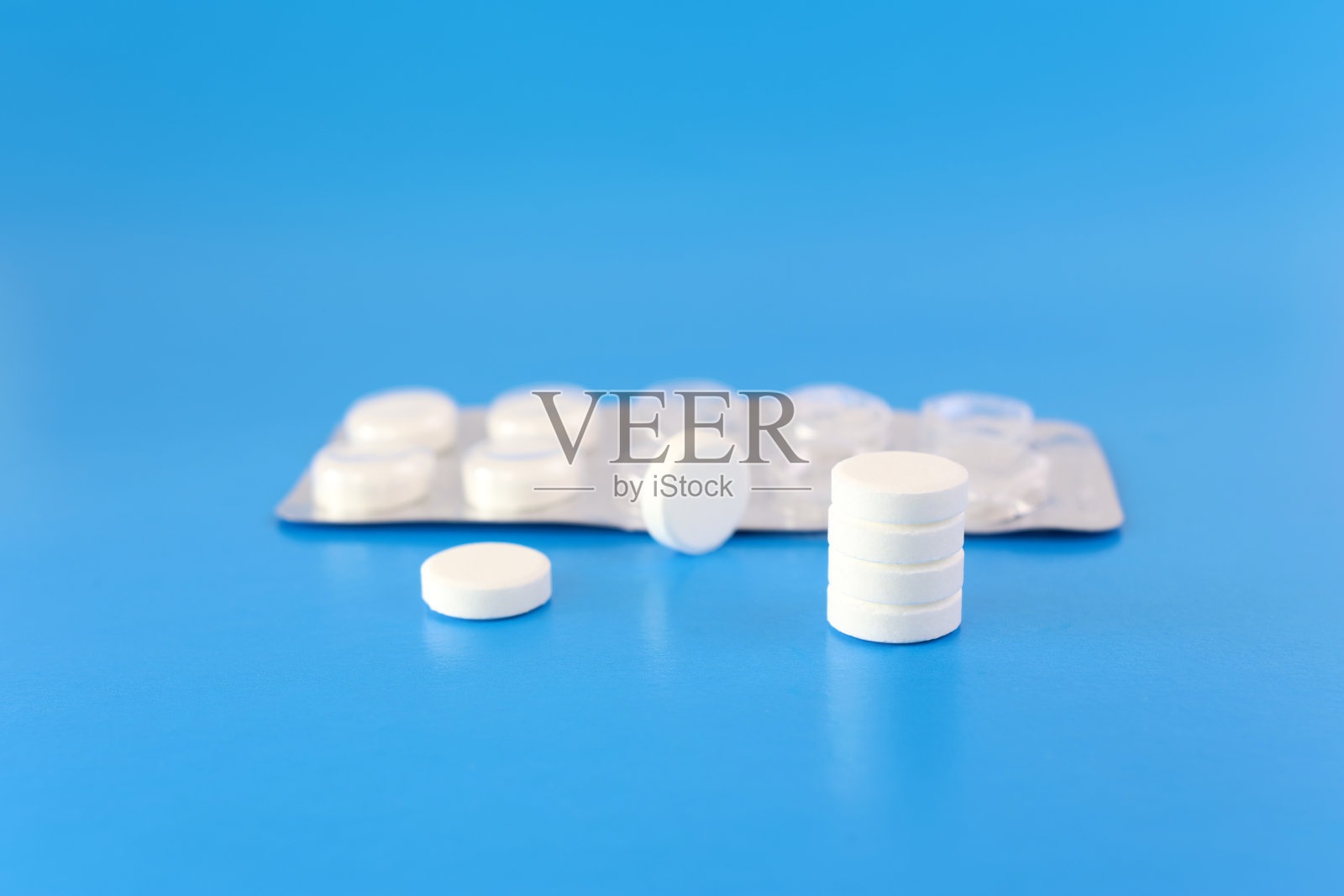 一包蓝色背景的白色药片。医药和保健。照片摄影图片